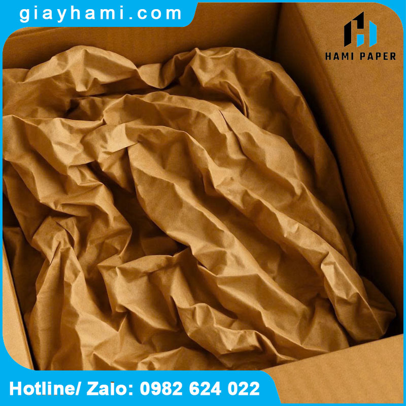 Công nhân xưởng nội thất dùng giấy Kraft bọc bề mặt bàn trước vận chuyển